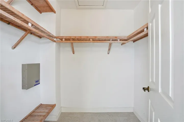 Spacious closet featuring light tile patterned floors - Virtually Edited Image