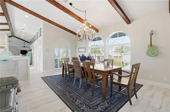 Dining space with healthy amount of natural light, a chandelier, and light wood-type flooring - Virtually Edited Image
