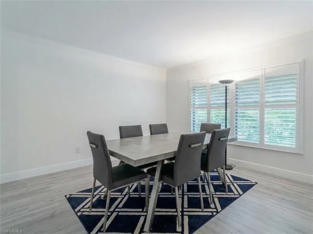 Light wood-finish flooring with white walls and crown molding