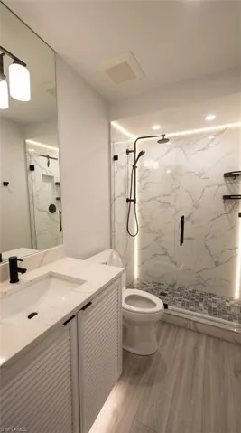 Modern bathroom with a white louvered vanity, integrated sink, and matte black fixtures