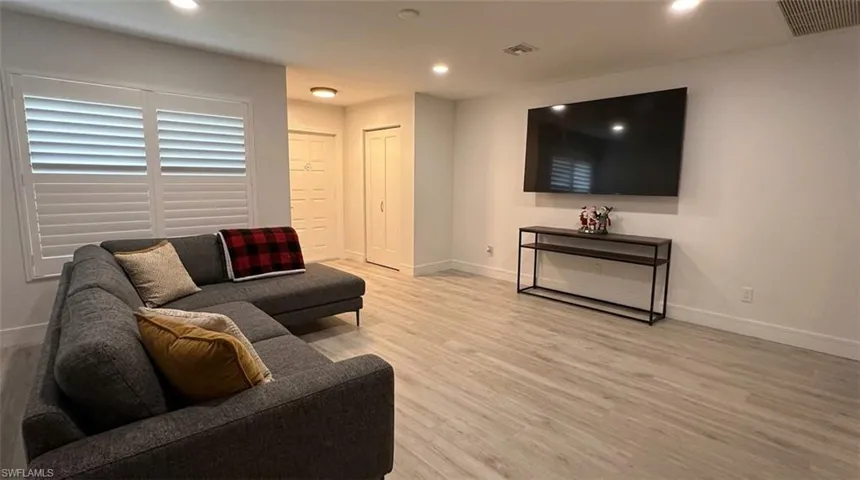 Recessed lighting illuminates wood-finish flooring