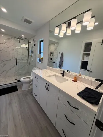 Dual vanity with integrated sink, white cabinetry, and matte black hardware