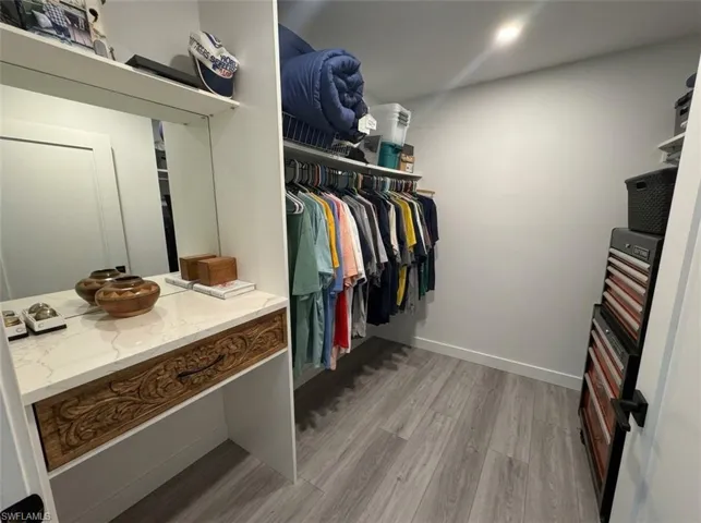Built-in vanity with a stone-finish countertop and carved wood-finish drawer