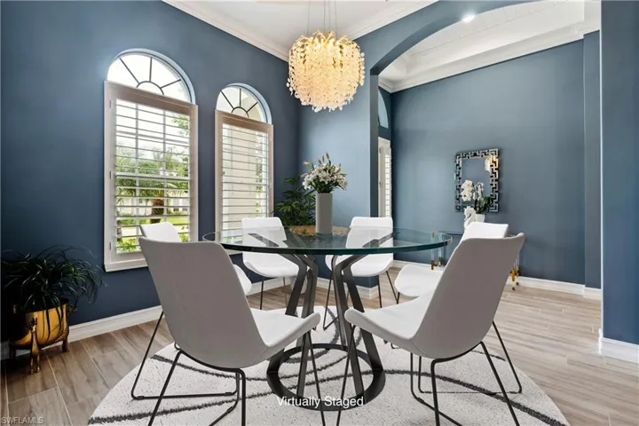 Virtually staged dining space with a chandelier, light wood-style floors and more.