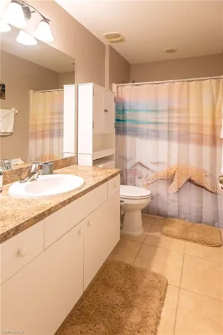 Bathroom with tile patterned flooring, vanity, and toilet
