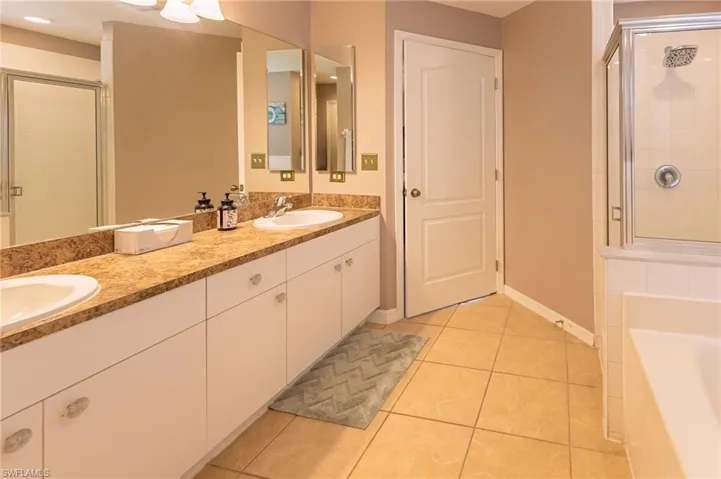 Bathroom with tile patterned floors, separate shower and tub, and vanity