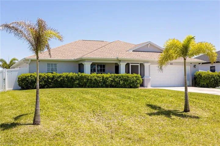 Single story home featuring a garage and a front yard