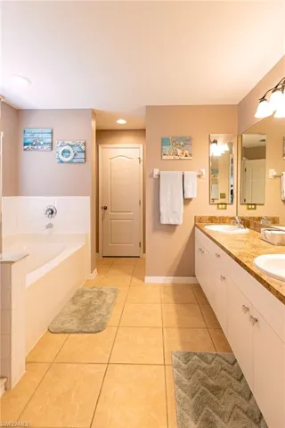 Bathroom featuring vanity, tile patterned floors, and a tub