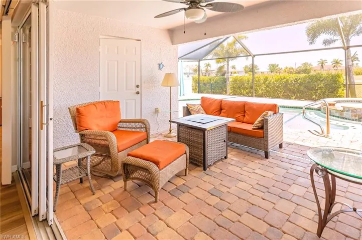 View of patio / terrace with a swimming pool with hot tub, an outdoor hangout area, ceiling fan, and a lanai