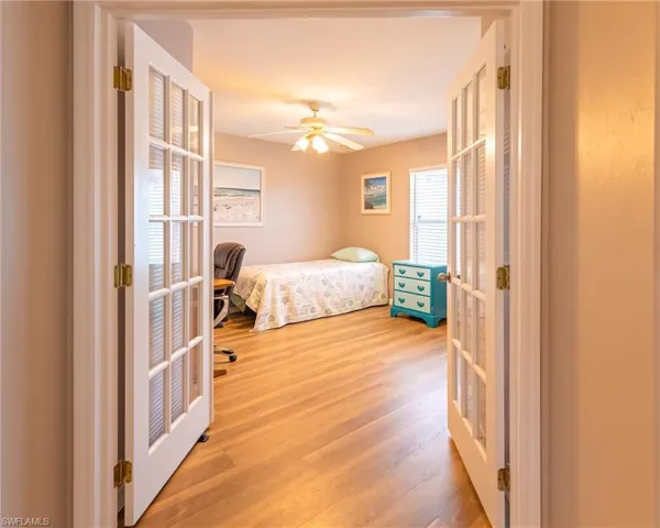 Bedroom featuring hardwood / wood-style floors, ceiling fan, and french doors