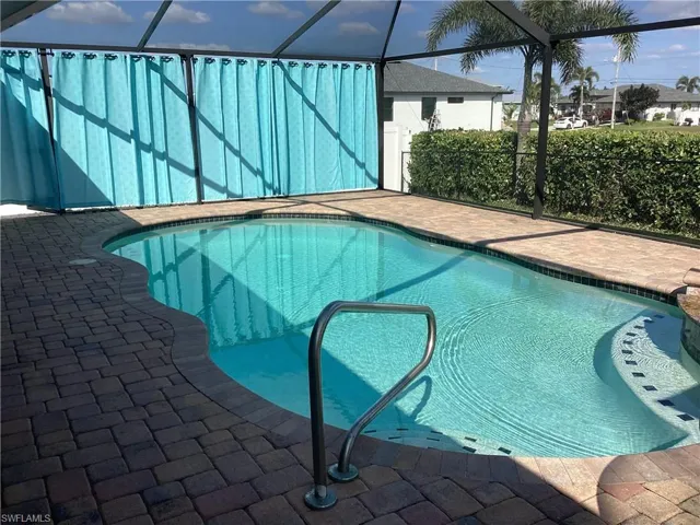 View of swimming pool featuring a lanai