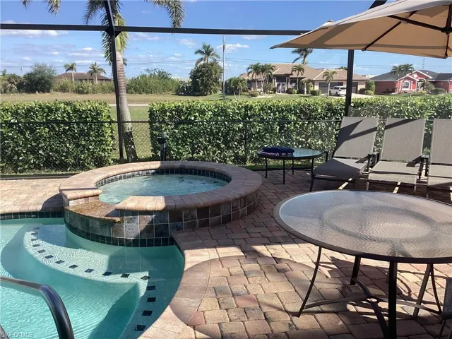 View of patio with a swimming pool with hot tub
