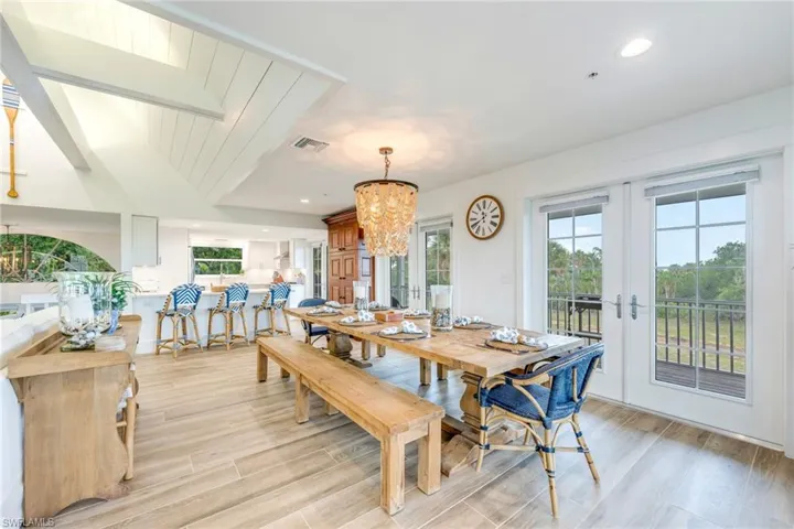 Dining room featuring a chandelier, recessed lighting, wood finish floors, and french doors