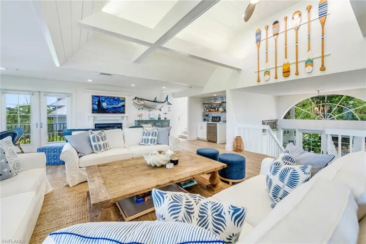Living area featuring wood finished floors, beam ceiling, and a fireplace