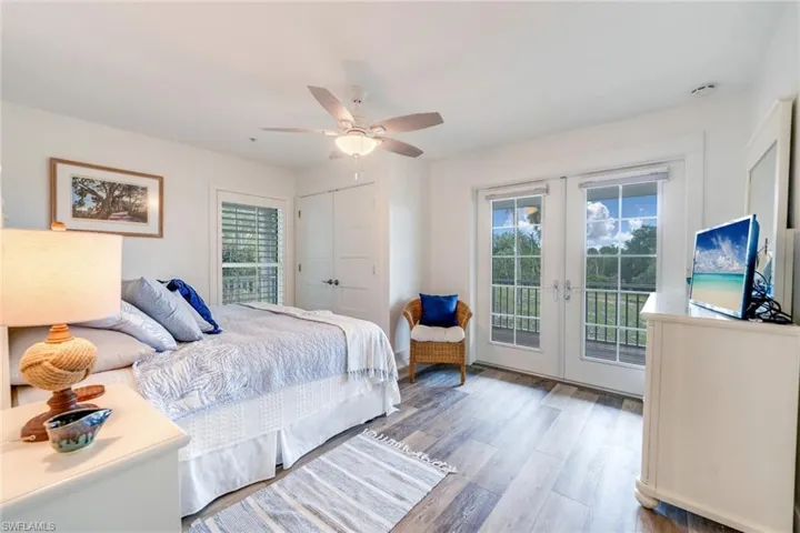 1st floor Bedroom featuring access to outside, multiple windows, wood finished floors, and french doors