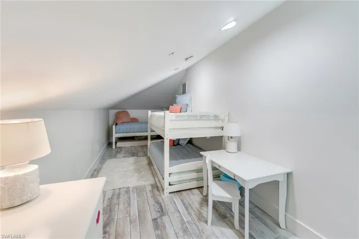 Bedroom featuring light wood-style flooring and lofted ceiling
