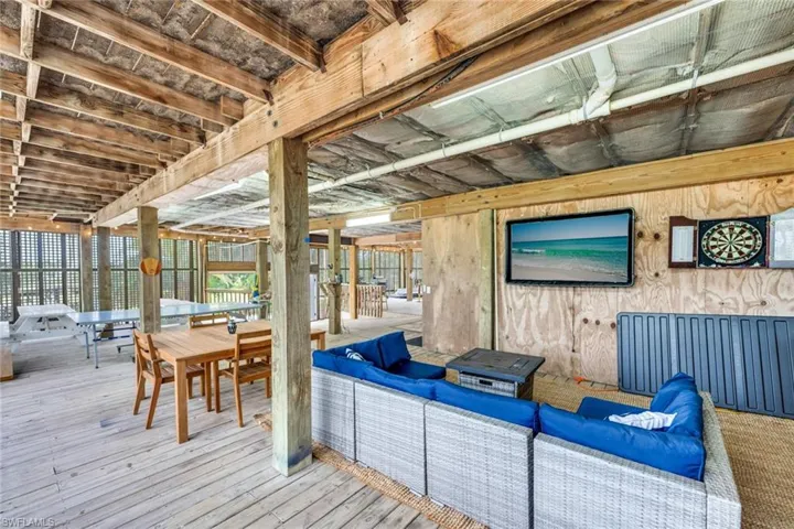 Ground floor gameroom; Wooden terrace featuring an outdoor hangout area and outdoor dining space