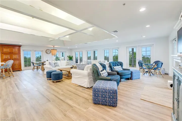Living room with french doors, light wood finished floors, recessed lighting, and beamed ceiling