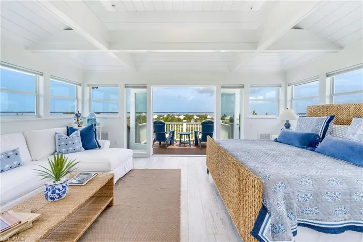 Bedroom with hardwood / wood-style floors, access to exterior, and a wood ceiling with exposed beams