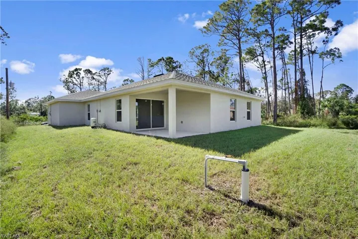 Rear view of property with a yard