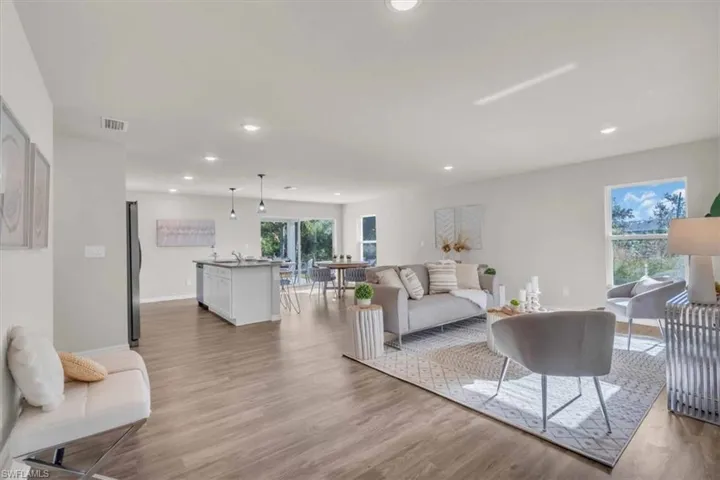 Living room with light hardwood / wood-style flooring and sink