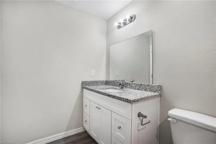 Bathroom featuring toilet, hardwood / wood-style floors, and vanity