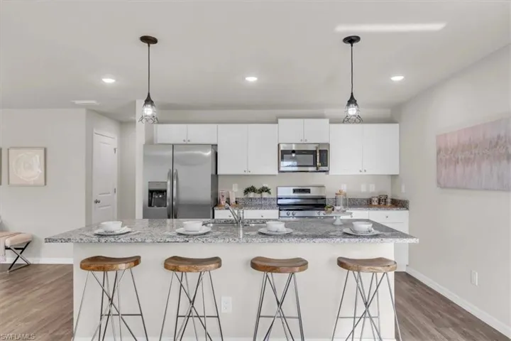 Kitchen with stainless steel appliances, a kitchen bar, and a kitchen island with sink