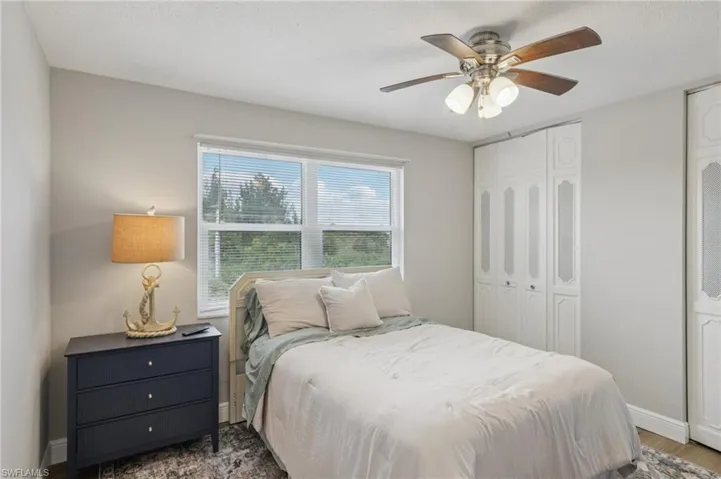 Bedroom featuring ceiling fan, two closets, LVP floors,