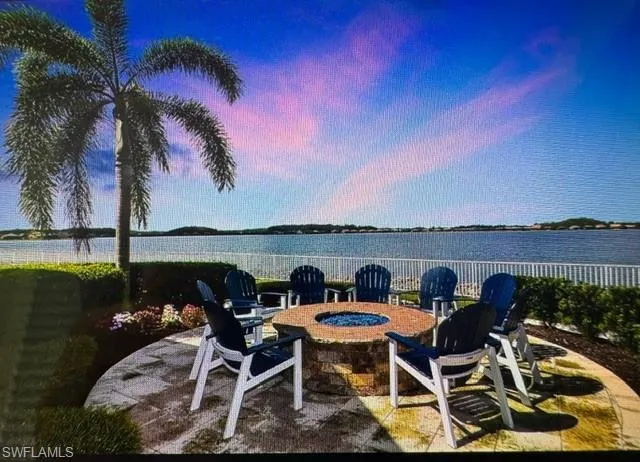 Patio terrace at dusk with a fire pit and a water view