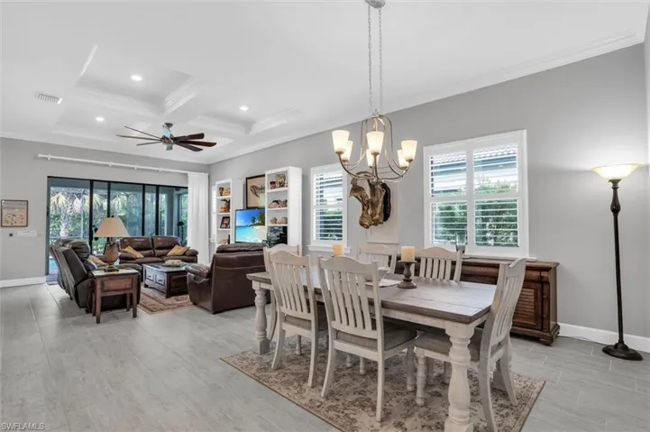 Dining area with crown molding, coffered ceiling, baseboards, beam ceiling, and a ceiling fan