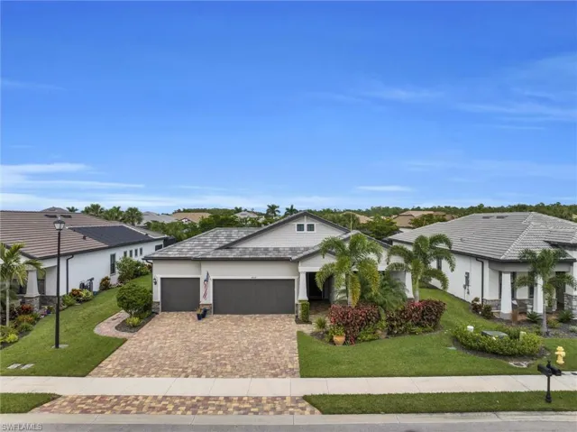 View of front of house with a garage, driveway, a front lawn, stucco siding, and a residential view