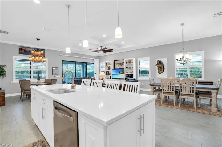 Kitchen featuring dishwasher, a sink, a chandelier, crown molding, and recessed lighting