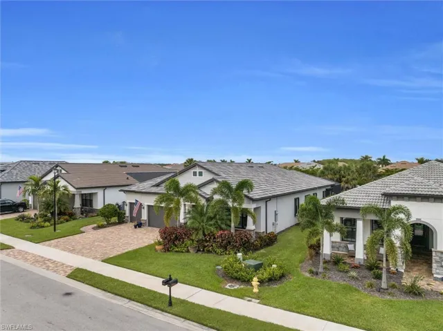 View of front of property featuring driveway, an attached garage, a front yard, and stucco siding