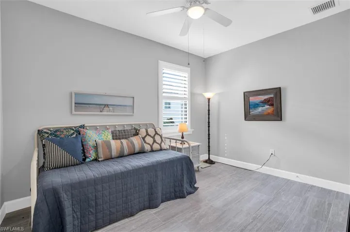 Bedroom with baseboards, wood finished floors, and a ceiling fan