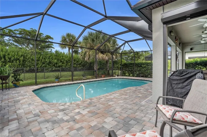 View of pool with ceiling fan, a patio area, and glass enclosure