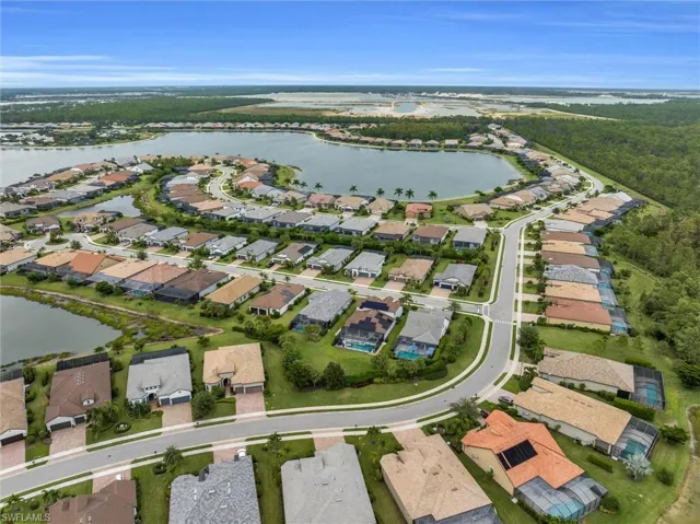 Aerial view of property's location featuring a nearby body of water and nearby suburban area