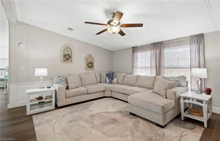 Living room with vaulted ceiling, wood-type flooring, and ceiling fan