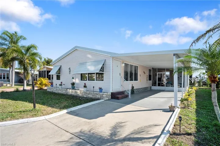 View of front facade with a carport and a front yard