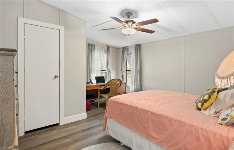 Bedroom with dark hardwood / wood-style floors and ceiling fan