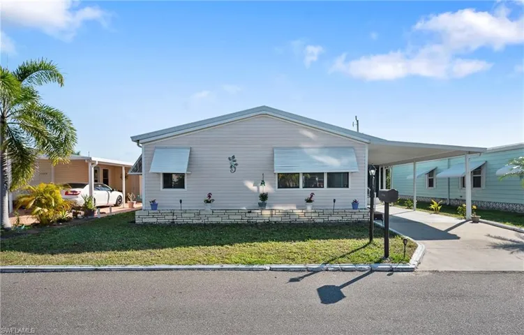 View of front of property with a front lawn and a carport