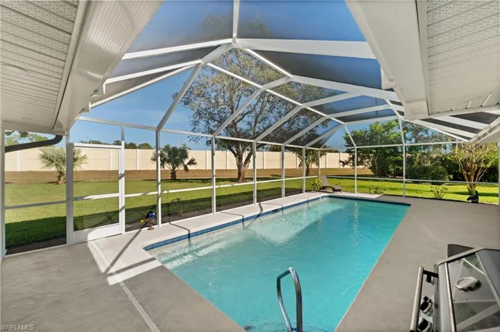 A sparkling pool set beneath a soaring screened enclosure, designed for year-round enjoyment, morning laps, and sun-filled afternoons.