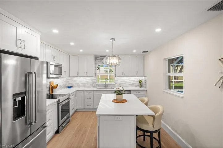 Abundant natural light pours through well-positioned windows, illuminating every detail of the designer kitchen while inviting views of the outdoors.