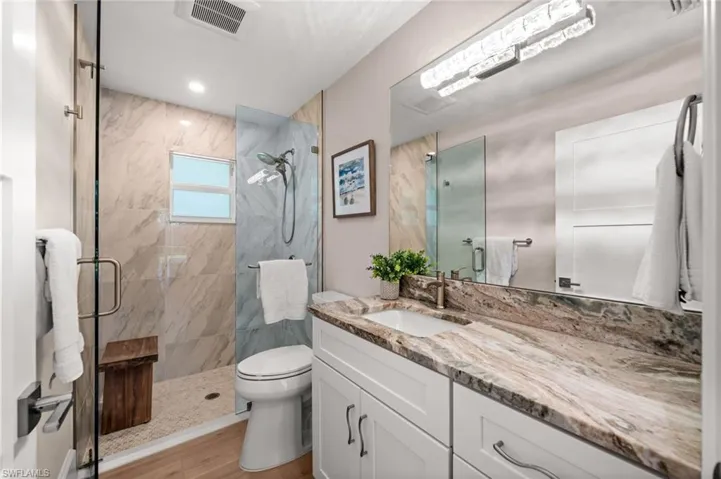 Warm earth-toned stone and modern chrome fixtures elevate this guest bath, delivering both sophistication and function in a serene design.