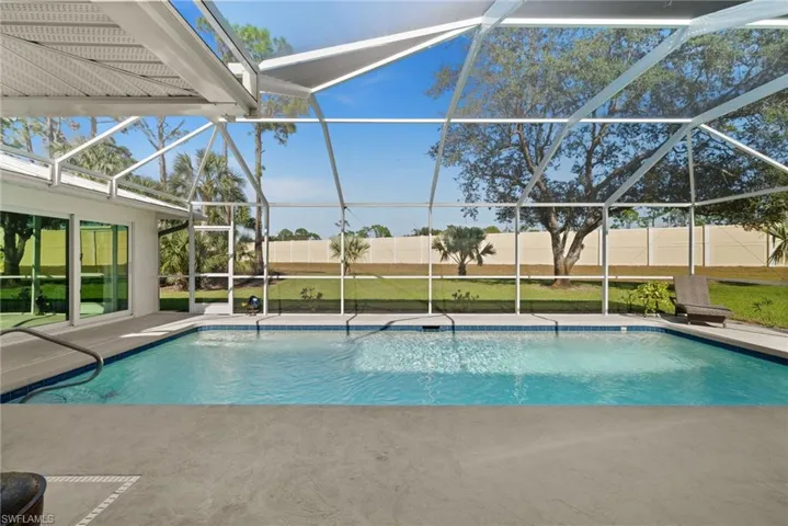 Resort-style living continues outdoors with a pristine pool framed by lush green space, offering both privacy and relaxation.