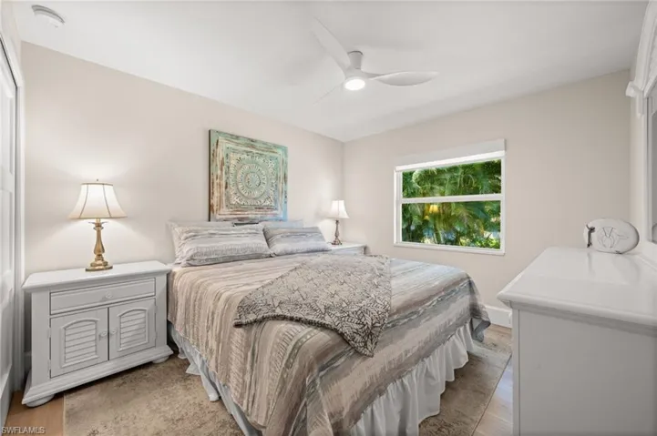 A light-filled guest suite designed for comfort, featuring tasteful décor, fresh neutrals, and a private view framed by mature landscaping.