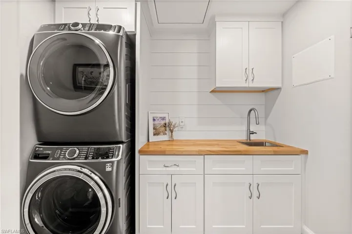 Every detail considered, from shiplap accents to rich butcher-block surfaces, this laundry area brings style and efficiency to everyday living.