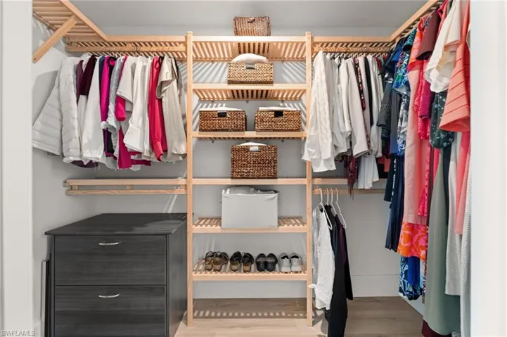 A thoughtfully organized walk-in closet with custom shelving, ample hanging space, and room for shoes, storage, and seasonal wardrobes.