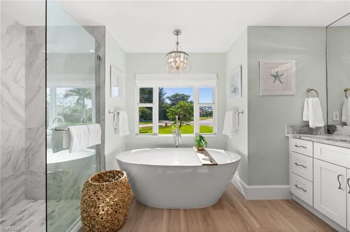 A luxurious escape, the freestanding tub and glass shower blend modern luxury with coastal tranquility, creating a peaceful haven within the home.