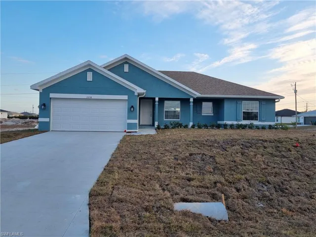 Ranch-style house with stucco siding, a garage, concrete driveway, a front lawn, and roof with shingles