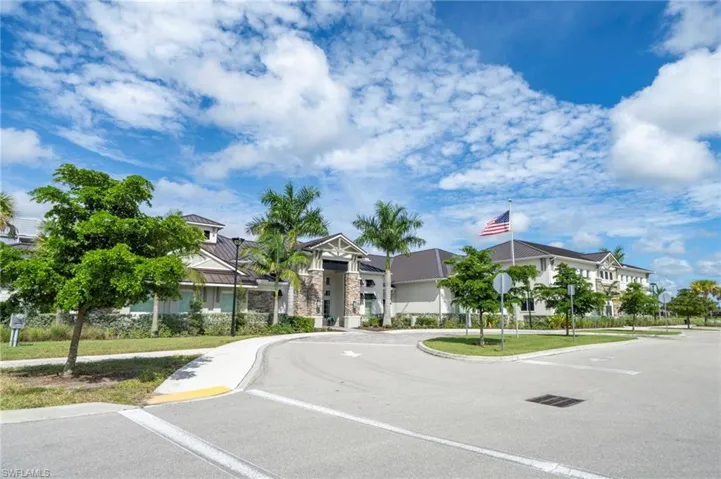 Exterior facade featuring stone veneer detailing, a multi-pitched roof with metal roofing material, and mature palm landscaping